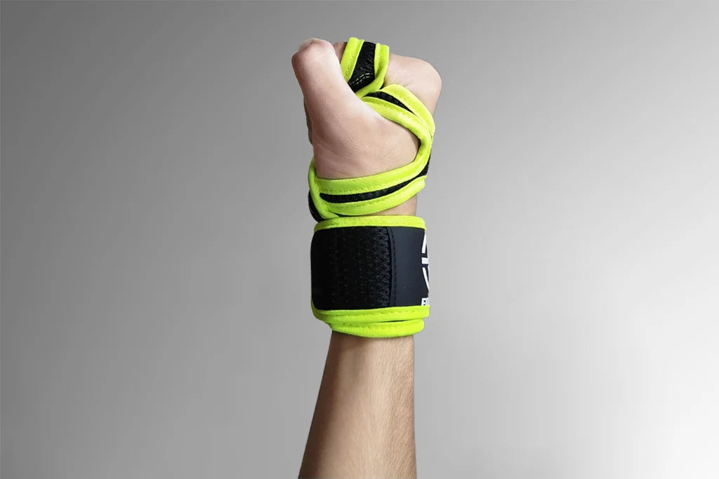 Hand with green wrist wraps on a gray background